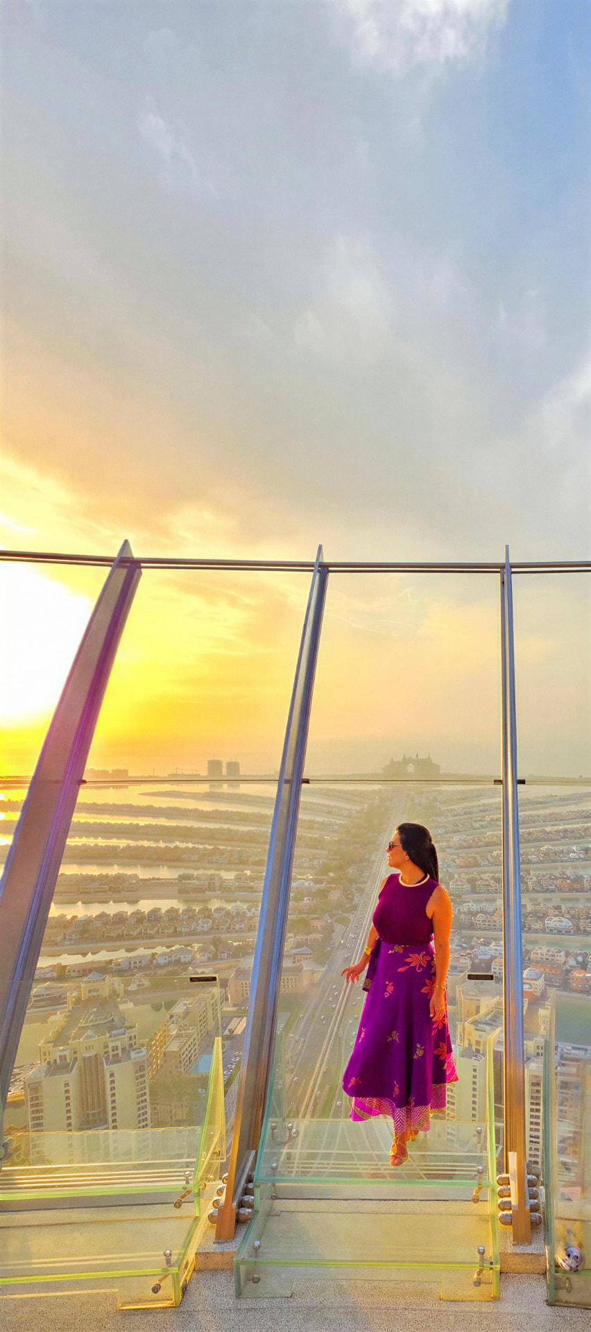 Chrys Cintra, CEO e Travel Designer da GlowUp Tur, em um mirante com vista panorâmica de Dubai ao pôr do sol